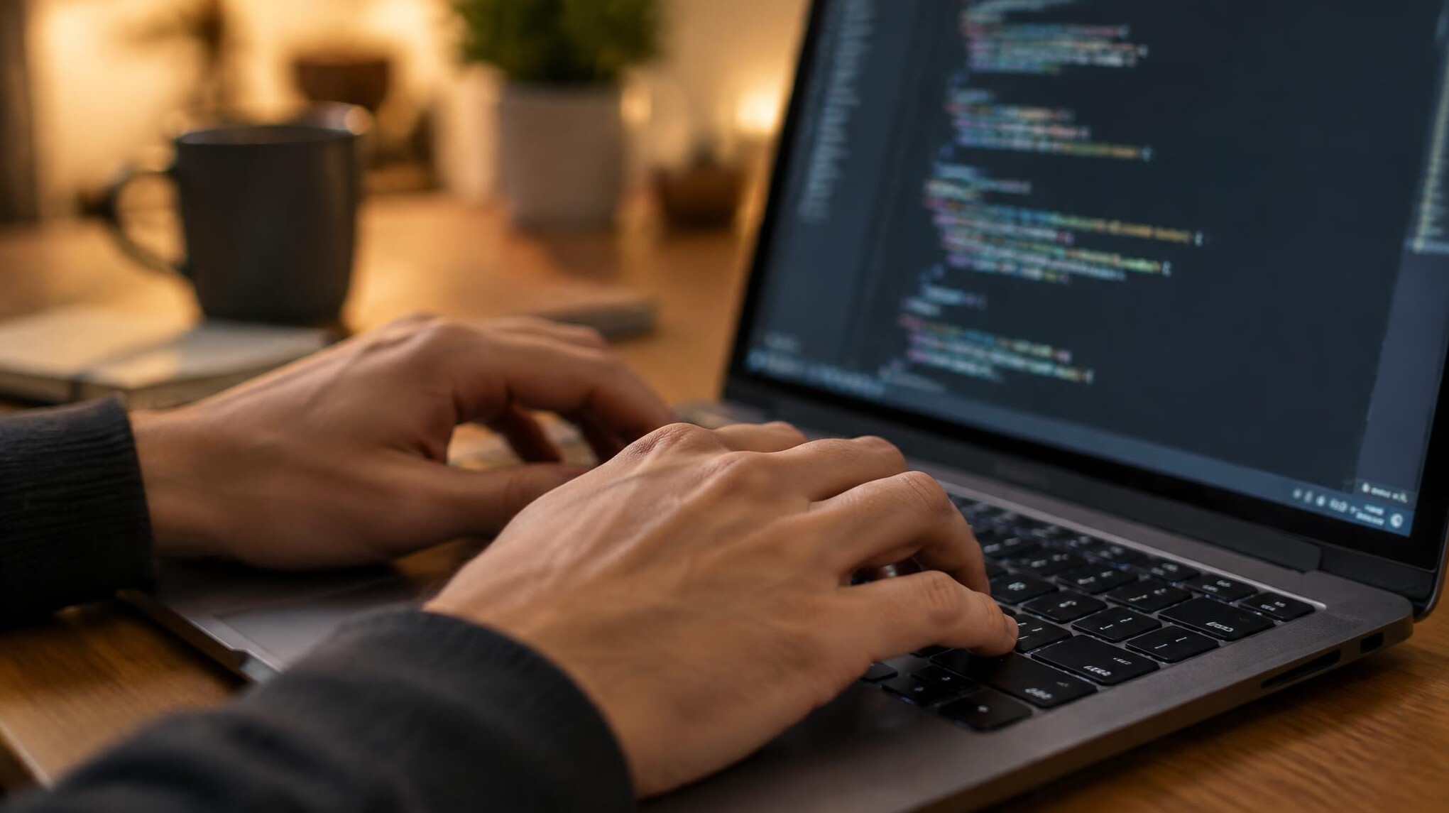 Close-up of hands typing on a laptop keyboard at an angle