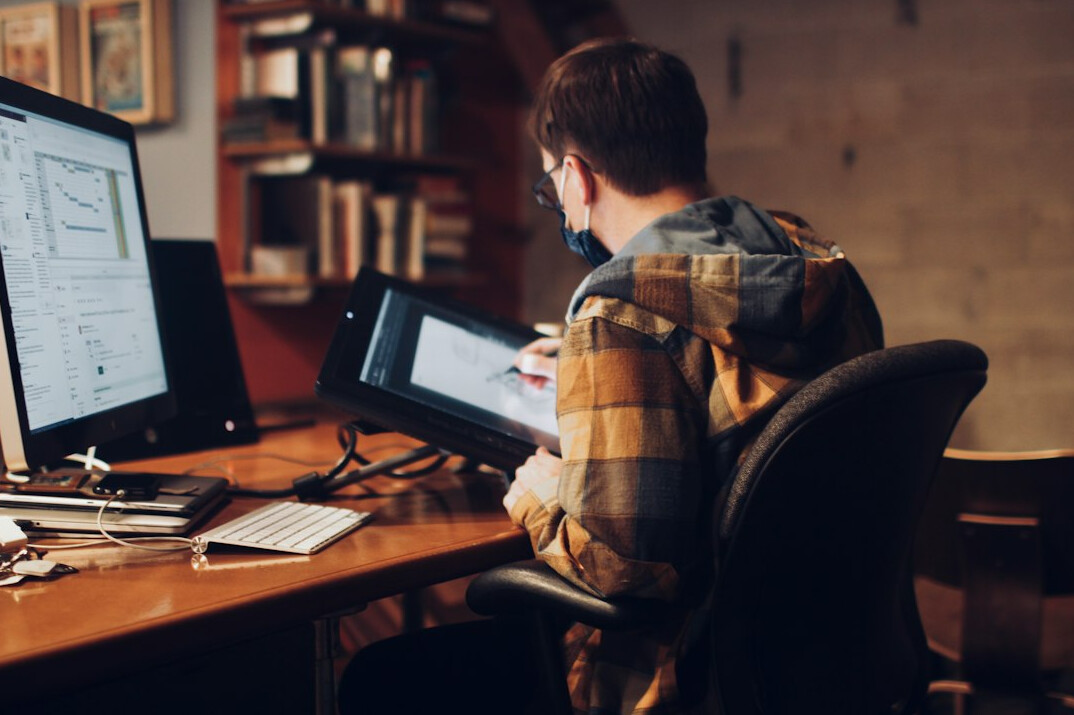 person writing code at desk